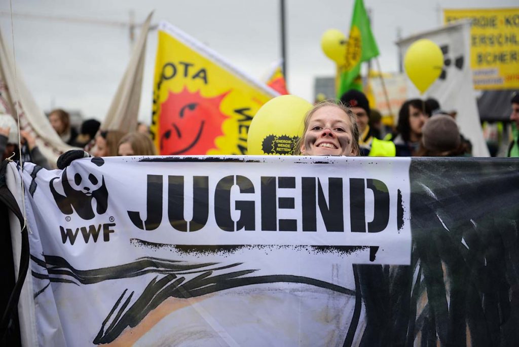 Eine Jugendliche hält das WWF Jugend Banner, während der Berliner Energiewende-Demo