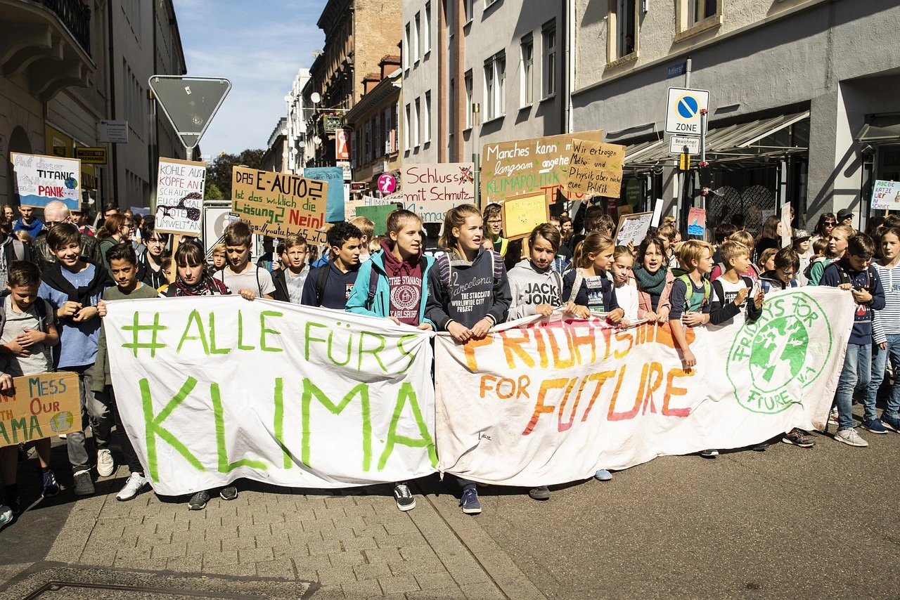Eine große Gruppe von Demonstranten auf einer Straße mit dem Banner "#Alle fürs Klima!"