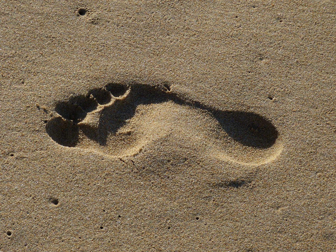 Das Foto zeigt eine Sandfläche. Darauf ist der Fußabdruck eines Menschen zu sehen.