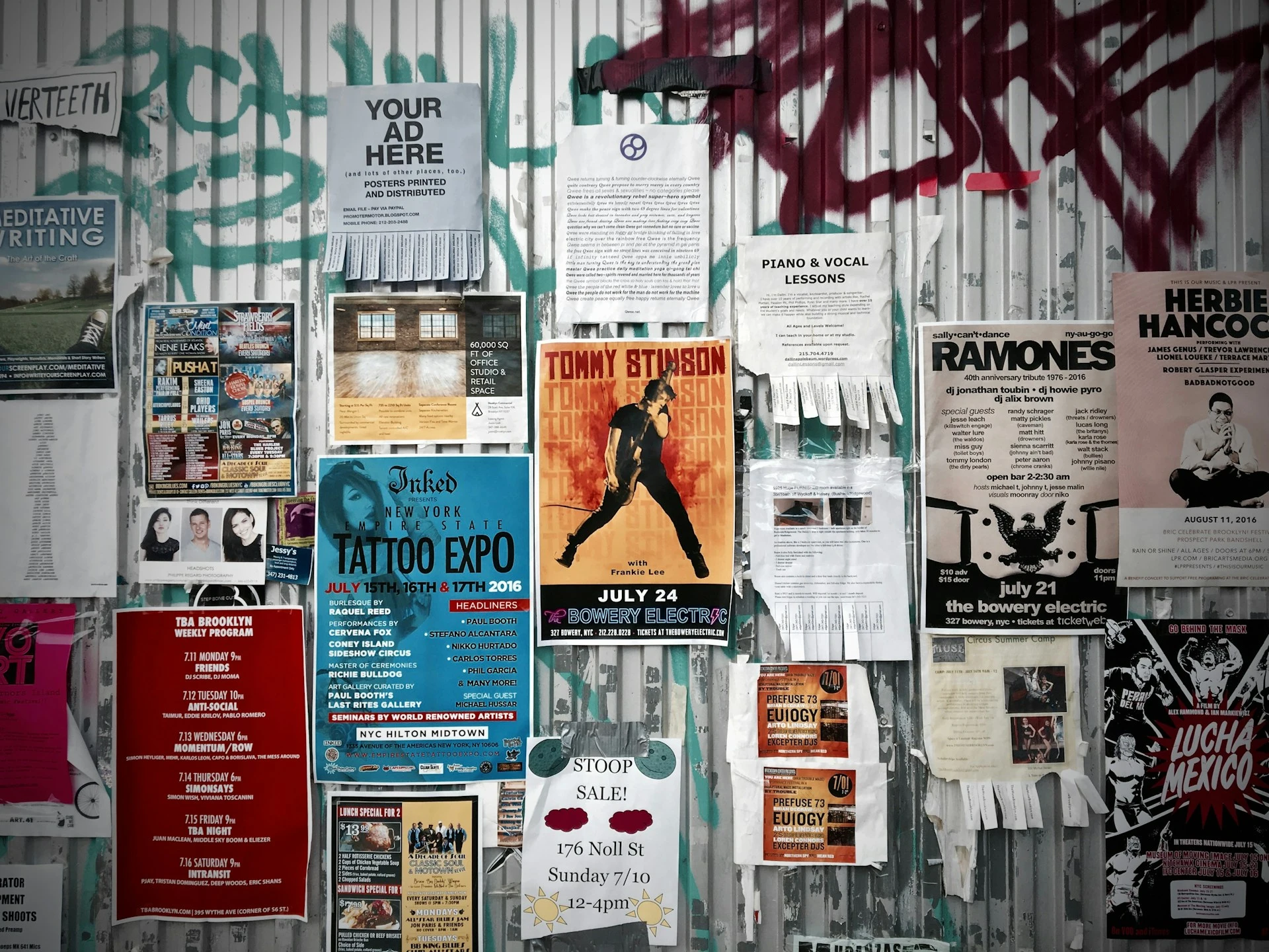 Eine Wand, die mit Werbung und Plakaten vollgeklebt ist