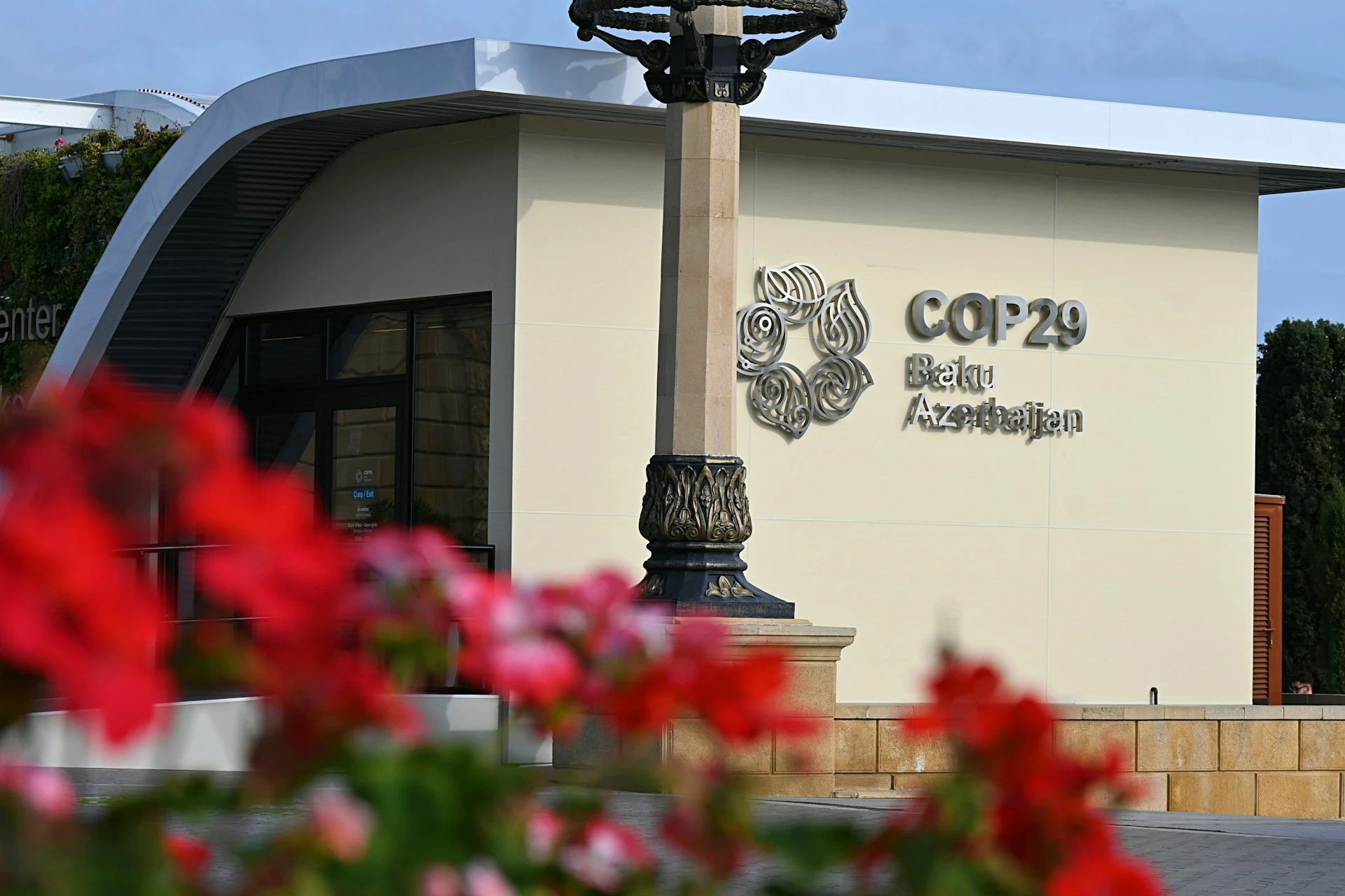 Das Foto zeigt ein helles Gebäude. Darauf ist der Schriftzug "COP29" zu sehen.