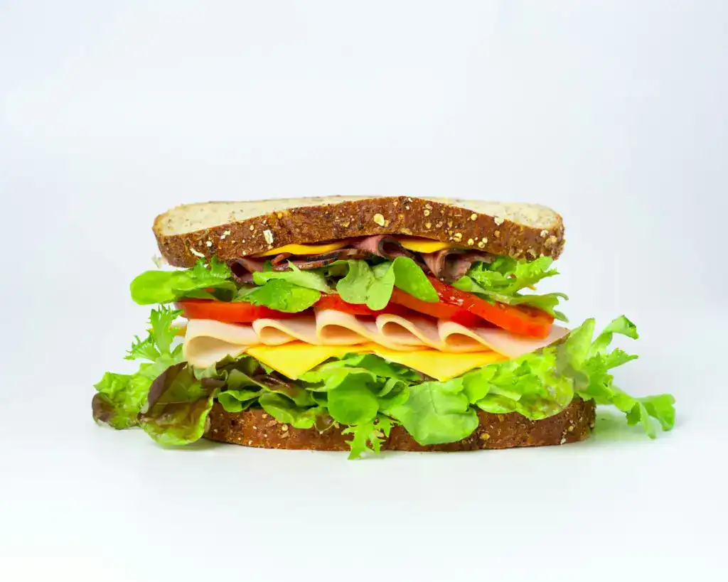 Ein dick belegtes Brot mit Salat, Käse, Tomaten