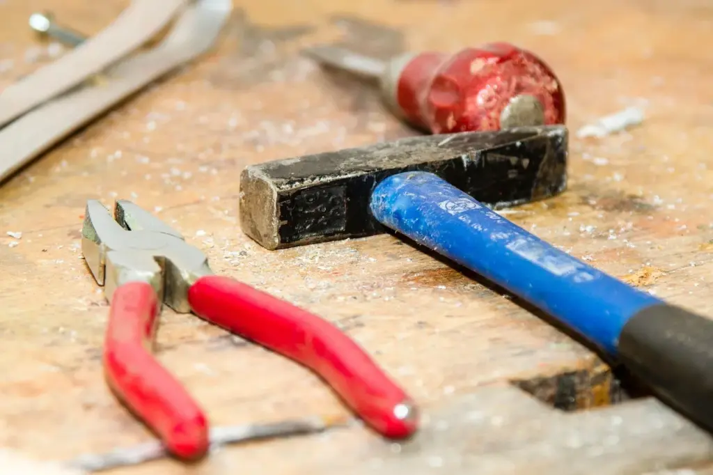 Hammer, Zange und Schraubenzieher auf einer Arbeitsfläche