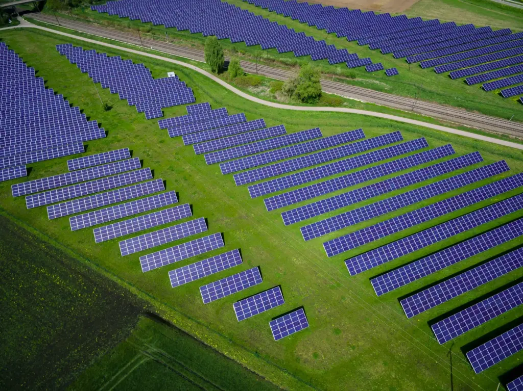 Ein Solarpark mit mehreren Reihen Solarpanels auf einer Rasenfläche