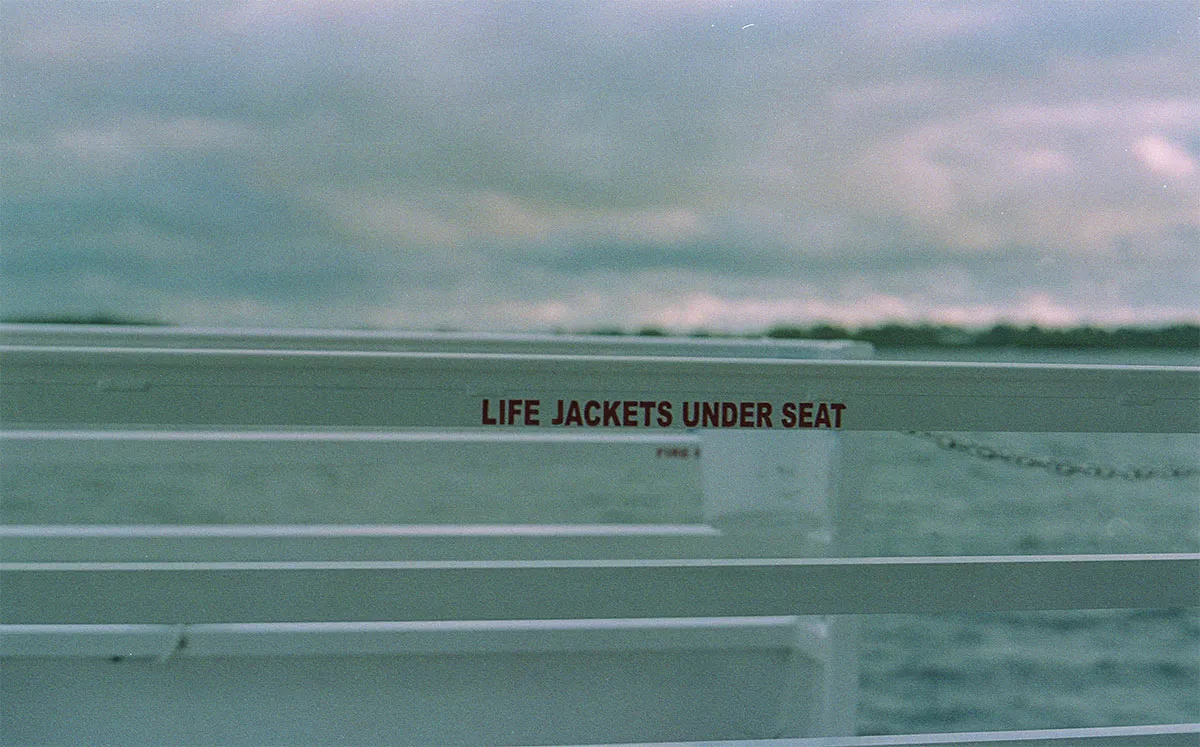 Reling einer Fähre mit der Aufschrift Life Jackets Under Seat