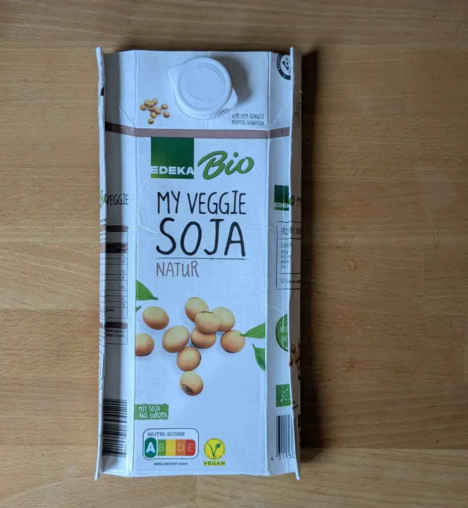Das Bild zeigt die Soja-Milchtüte, deren langen Seitenränder grob zwei Zentimeter weit nach innen gefaltet sind.
