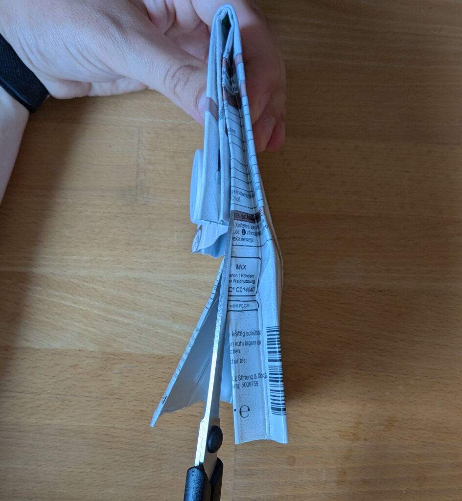 Die Seiten werden mit einer Schere eingeschnitten.