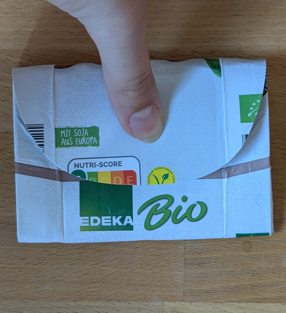 Das fast fertiggestellte Portemonnaie wird mit dem Daumen auf den Schraubverschluss aufgedrückt.