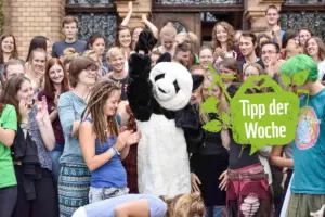 Eine Gruppe der WWF Jugend jubelt jemandem zu, der mit einem Pandakostüm verkleidet ist.