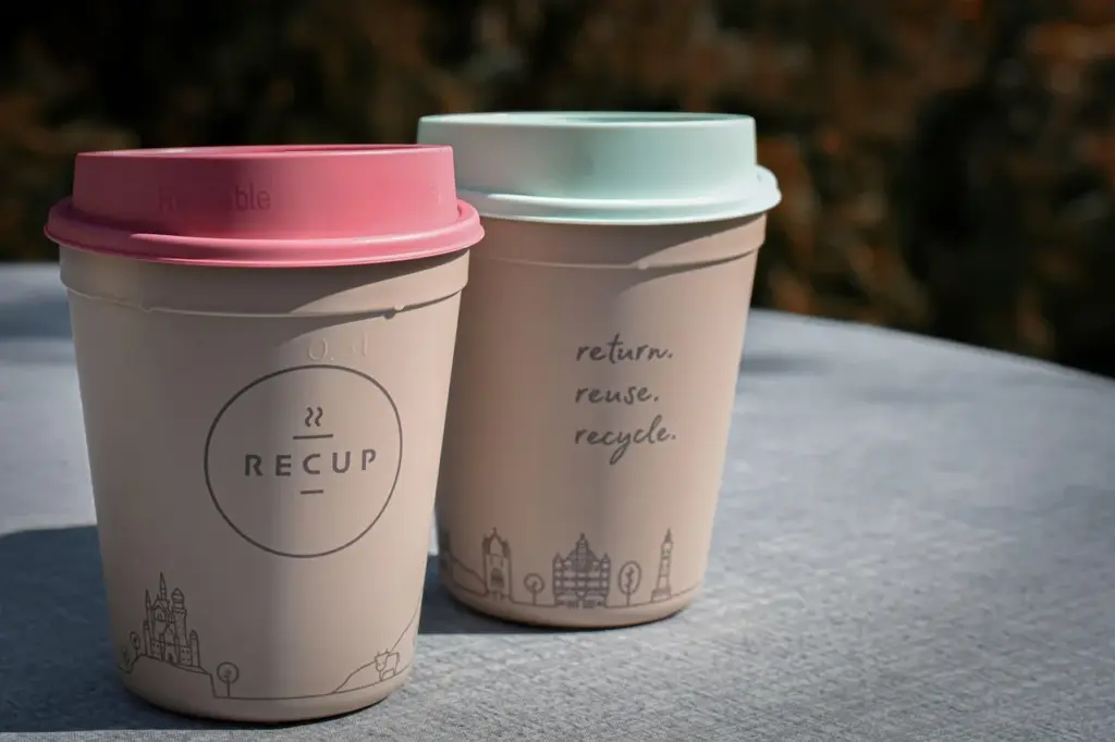 zwei Mehrweg-Recup-Becher auf einem Tisch