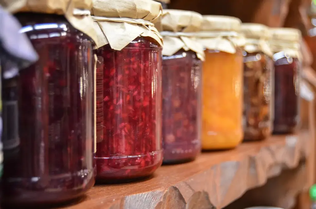 mehrere Gläser Marmelade stehen auf einem Holzregal