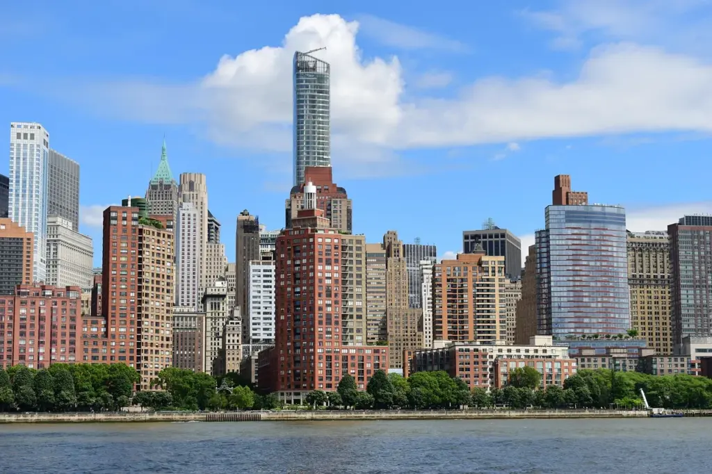 Blick auf die Skyline von New York bei Tag, im Vordergrund ein Fluss