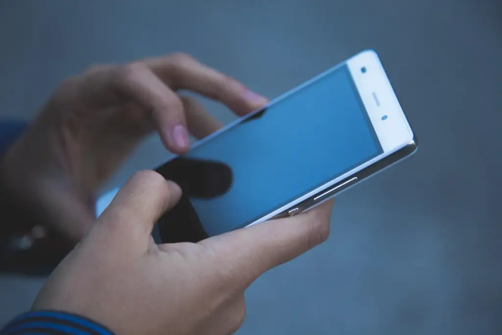 Das Bild zeigt zeigt die Hände einer Person, die ein Smartphone halten.