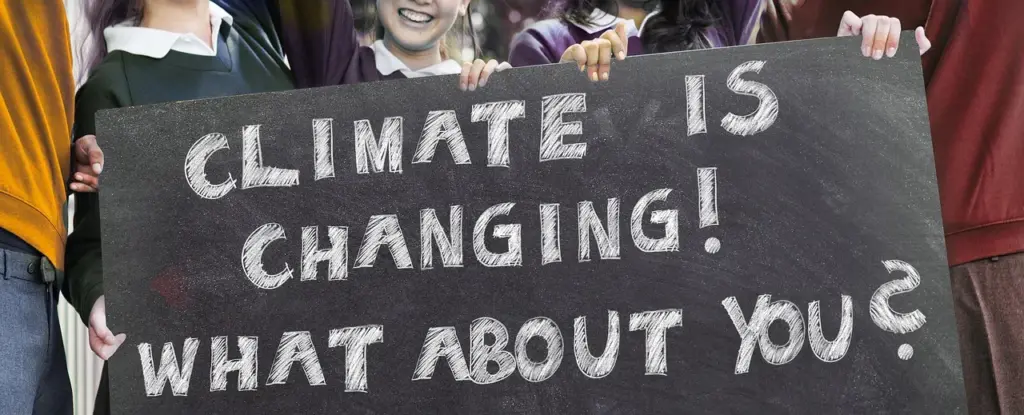 ein großes, schwarzes Plakat mit der weißenAufschrift "Climate is changing! What about you?" wird von jungen Menschen gehalten