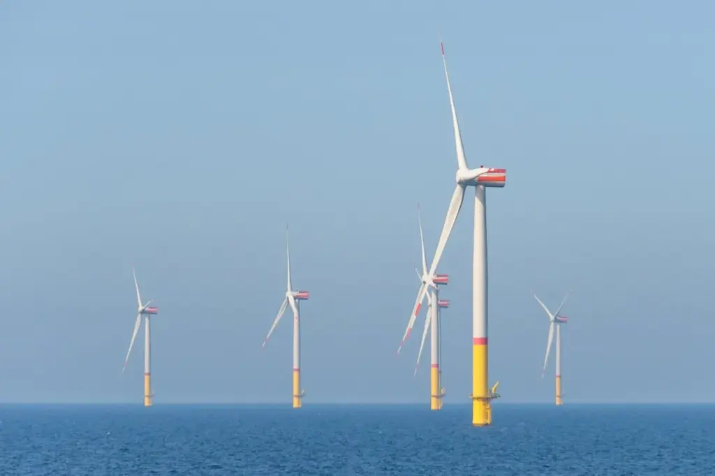 mehrere Windkraftanlagen stehen im Meer